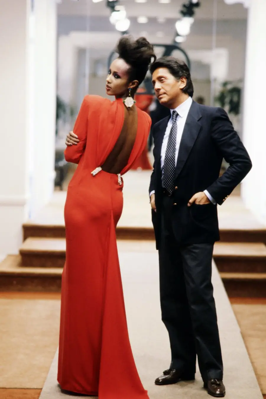 Valentino posa con Iman, vestida con un vestido de noche de alta costura en Valentino red, de la colección otoño de 1984.