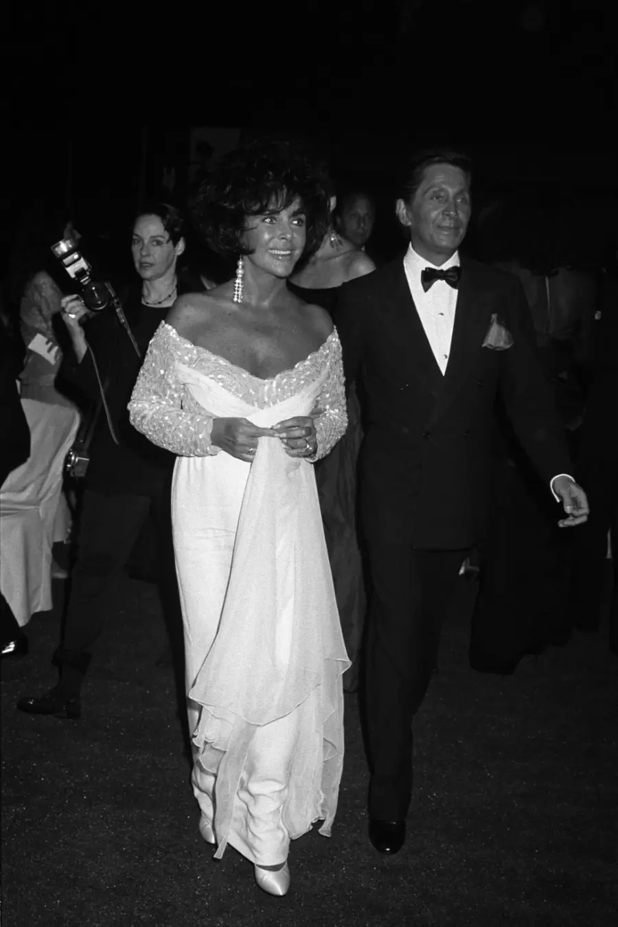 La actriz Elizabeth Taylor (izq.) y el diseñador de moda Valentino Garavani asisten a una gala de Valentino en 1991.