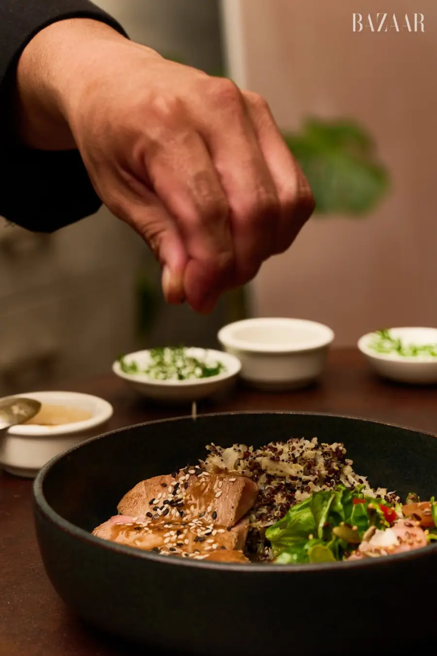 Una base  de quinoa cocinada con leche de coco, con ensalada orgánica con semillas y vinagreta de maracuyá, con un atún rojo.