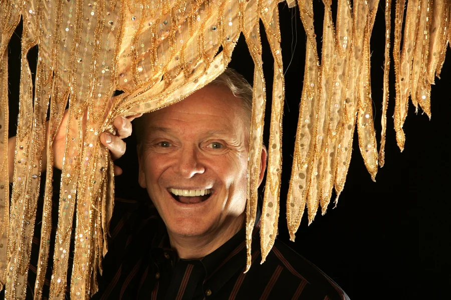 Bob Mackie. Fotografía: Cortesía Mel Melcon, Getty Images. - Fashion designer Bob Mackie stands behind print silk crepe de chine, at his design studio in Studio City on May 9, 2008. Mackie designed the costumes 