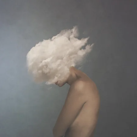 surreal image of a white cloud covering a woman's face, concept of freedom