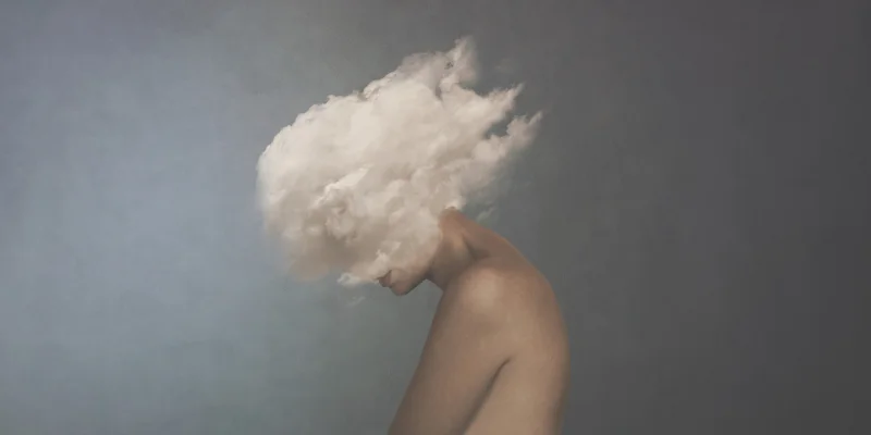 surreal image of a white cloud covering a woman's face, concept of freedom